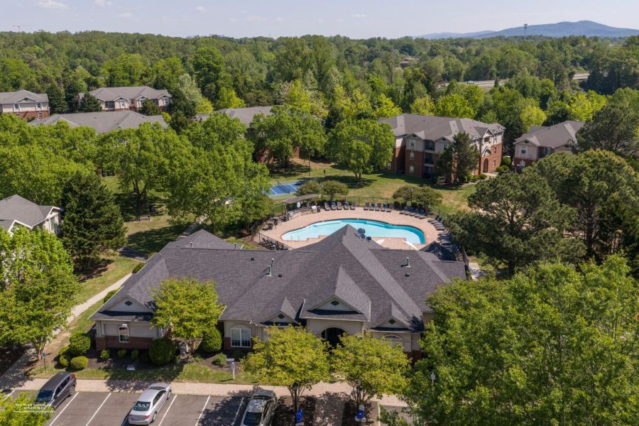 Attain on 5th apartment homes with Aerial view of an apartment complex with a central outdoor pool surrounded by trees and greenery.