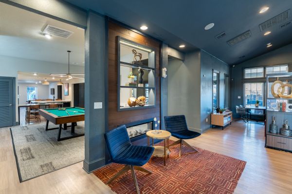 Attain on 5th apartment homes with Smiling woman sitting on a couch with a laptop and holding a cup of coffee in a sunlit room.