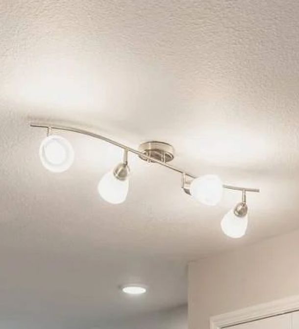 Attain on 5th apartment homes with Ceiling-mounted modern light fixture with four adjustable bulbs on a curved metal track, all illuminated.
